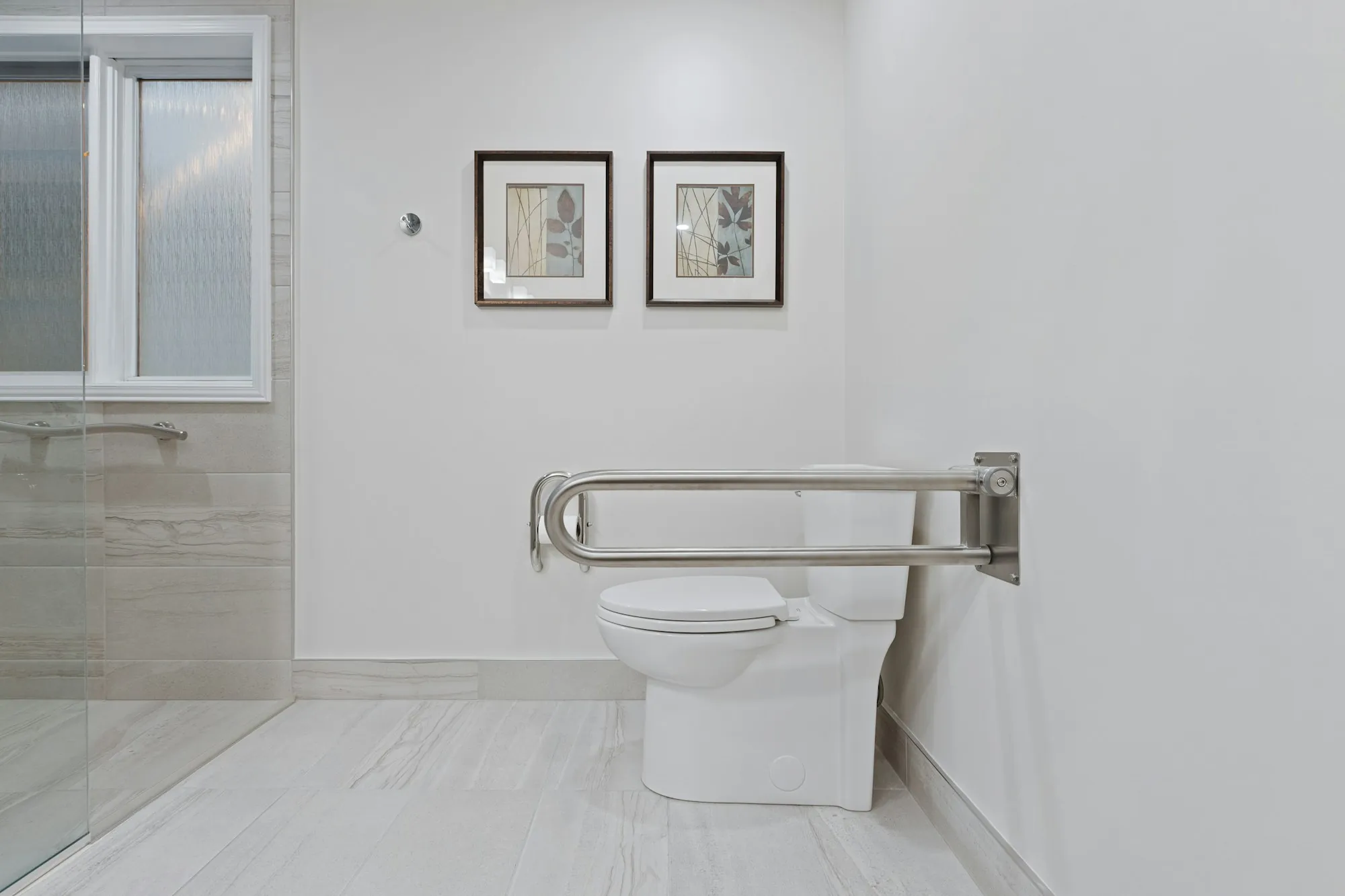 A bathroom fitted with a shower seat and support rails, towels set out